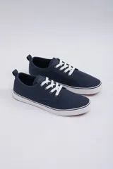 Zapatillas acordonadas de lona color azul marino con cordones blancos y suela blanca.