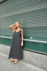 Vestido largo negro con estampado de lunares blancos, breteles finos y escote en V.