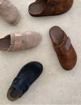 Suecos marrones de gamuza con hebilla lateral ajustable y suela de goma negra.