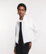 Campera blanca de viscolino, modelo globo, con cuello camisero, manga larga, cierre delantero y bolsillos fake.