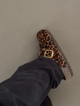 Zueco de cuero con estampado animal print, hebilla dorada y suela de goma.