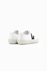 Zapatillas Veja modelo Nova, de caña baja, color blanco con logo lateral en negro y suela color crema. Fabricadas en lona de algodón orgánico.