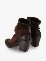 Bota corta de gamuza con estampado de leopardo en tonos marrones y negros. Presenta un taco ancho y alto de color marrón oscuro, punta cuadrada y cierre de cremallera en la parte trasera.