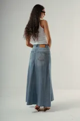 Falda larga de denim, tiro medio, color celeste claro con efecto desgastado. Presenta un corte amplio con paneles verticales que le dan volumen y caída.