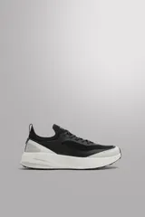 Zapatillas deportivas negras con detalles en gris y blanco, ideales para uso diario y carreras ligeras. Parte superior de tejido de punto transpirable, puntera y talón recubiertos con material Shield Protect Max, ajuste con cordones, tirador trasero, plantilla OrthoLite® extraíble, entresuela Spume Foam V3 y suela de goma.
