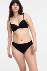 Conjunto de ropa interior blanco, compuesto por un corpiño de breteles finos y una bombacha tipo colaless con detalles de puntilla.