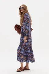 Vestido midi de lino con estampado floral, cuello mao, mangas largas con puños elásticos y corte holgado con frunce en el ruedo.