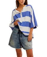 Remera de corte extragrande a rayas horizontales amarillas y blancas, confeccionada en jersey de peso medio, con textura suave y hombros caídos para un look relajado. Presenta un cierre frontal parcial con botón y terminaciones simples.