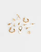 Set de aros dorados con diferentes diseños: aros tipo argolla, aros con forma de corazón, aros con perlas, aros con strass y aros tipo botón.