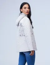 Campera capitoneada blanca de la marca Gallery, con cierre frontal, bolsillos, cinto ajustable y capucha desmontable.