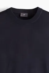 Buzo de punto fino suave color azul marino, con cuello redondo y corte ajustado.