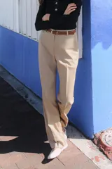 Pantalón negro de tiro alto con pernera recta, bolsillos frontales y falsos bolsillos con solapa en la espalda. Incluye cinturón marrón de cuero sintético.