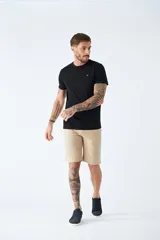 Bermuda color beige de corte chino, con bolsillos laterales, cierre con cremallera y botón, presillas para cinturón y logo bordado. Confeccionada en lino y algodón.