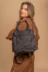 Mochila cartera negra de nylon con asas superiores y correas ajustables para usar como mochila. Cuenta con un compartimento principal amplio, un bolsillo frontal con cierre y bolsillos laterales.