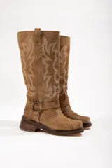 Bota de caña alta color marrón de cuero gamuzado, con bordado decorativo en la caña, correa con hebilla y taco cuadrado.