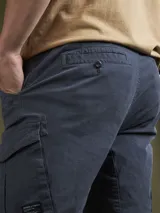 Pantalón cargo color marrón con bolsillos laterales con solapa y corte ajustado.