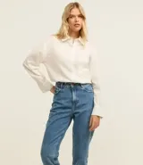 Pantalón mom jean de tiro alto, color celeste, con bolsillos delanteros y traseros, cierre con cremallera y botón, y ruedo doblado.