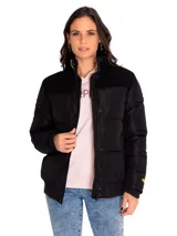 Campera puffer negra para mujer, marca Caterpillar. Cuenta con cuello alto, cierre frontal con botones a presión, bolsillos laterales inferiores, puños y cintura acanalados. Tiene un parche con el logo de Cat en la manga izquierda y forro estampado con el logo de Caterpillar.