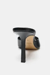 Zapato tipo mule de cuero negro con tira delantera y tacón fino alto. Diseño con punta redonda. Altura del tacón: 8 cm.