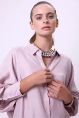 Camisa de manga larga color rosado oscuro/terracota, con cuello camisero y botones frontales. Presenta un calce holgado y tejido con caída.