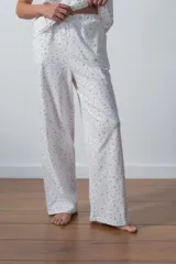 Conjunto de pijama blanco con estampado de lunares rojos, compuesto por una remera de mangas cortas y un pantalón palazzo.
