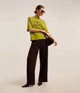 Remera verde de mangas cortas, confeccionada en malla, con cuello redondo y lettering "happy hour" estampado en el pecho.