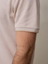 Chomba manga corta color beige con cuello clásico y tapeta de dos botones. Tiene un pequeño logo bordado en el pecho. Corte clásico.