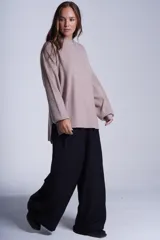 Sweater color beige de tejido de punto acanalado, con cuello redondo y mangas largas. Tiene corte holgado y aberturas laterales en el ruedo.