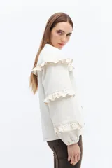 Campera de jean gris oscuro con volados en el frente y las mangas, cierre con botones metálicos.