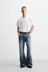 Pantalón de jean celeste con efecto lavado, corte flare fit y caída baggy desde la rodilla hasta el tobillo. Tiene cinco bolsillos y cierre frontal con botones.