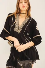 Blusa negra de viscosa crepe con escote en V, mangas largas con terminaciones elásticas y bordado de hilo color crema.