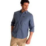Camisa de popelina verde con cuello abotonado, cierre frontal con botones, bolsillo de parche en el pecho izquierdo, mangas largas con trabillas para enrollar y dobladillo camisero.