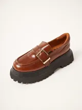 Mocasines marrones de cuero con hebilla dorada y plataforma track negra.