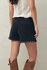 Short de jean azul con bordado floral en el frente y ruedo desflecado.