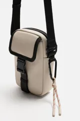 Bandolera vertical negra de acabado engomado con compartimento principal con cierre de cremallera y bolsillo interior plano. Bolsillo frontal con cierre de hebilla de liberación rápida. Asa de hombro ajustable y extraíble.