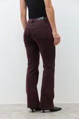 Jean de tiro alto, color bordó con efecto lavado o acid wash, corte oxford o acampanado.