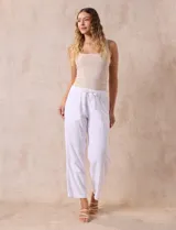 Pantalón largo de lino y rayón a rayas verticales grises y blancas. Tiene pretina elastizada con lazo de ajuste, bolsillos delanteros y traseros.