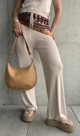 Pantalón acampanado color beige de tejido de punto acanalado.