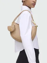 Cartera hobo de cuero color beige con doble correa de hombro y monedero colgante.