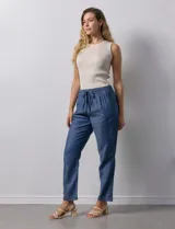 Pantalón celeste liso, marca Dash. Pretina elastizada, bolsillos delanteros y bolsillos traseros simulados.
