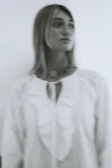 Vestido largo color marrón con tajos laterales, escote con volados y lazos con punteras metálicas.