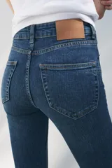 Jeans de tiro medio con cintura con trabillas, cinco bolsillos y corte bootcut.