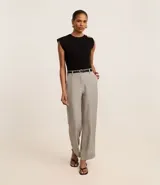 Pantalón de vestir gris claro, de corte recto, con bolsillos laterales y traseros. Se ajusta a la cintura con cinturón de cuero negro.