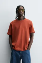 Remera color arena de corte recto, cuello redondo y mangas cortas.