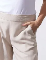 Pantalón crop de lino estampado con hojas en tonos verdes y azules. Tiene pretina trasera elastizada y bolsillos delanteros.