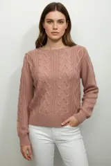 Sweater de punto acrílico color crema, con diseño de trenzas en el cuerpo y mangas, cuello redondo y calce holgado.