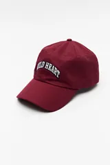 Gorra de béisbol color bordó con bordado frontal de la frase "Wild Heart" en blanco.