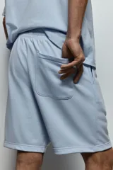 Short celeste de felpa liviana con cintura elástica ajustable con cordón, bolsillos laterales y bolsillo trasero.