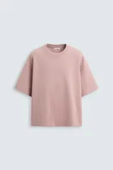 Camiseta rosa de corte recto, cuello redondo y mangas cortas. Estampado con efecto grabado combinado a tono en la espalda.