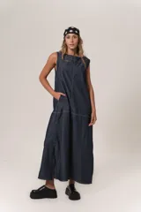 Vestido largo de denim azul oscuro, sin mangas, con escote cuadrado y pespuntes contrastantes en blanco. Presenta un calce holgado y tajos laterales.